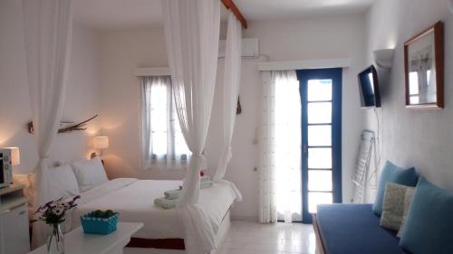 a white bedroom with a bed and a window at Big Blue Studios Myrtos in Myrtos