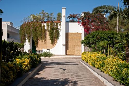 a street in front of a building with flowers at B&B Villa Ines in Leuca