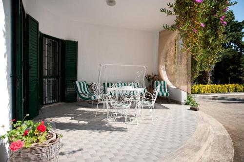 a patio with a table and chairs and flowers at B&B Villa Ines in Leuca