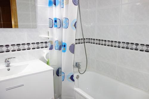y baño con cortina de ducha y lavamanos. en Turistic Home Velázquez, en Málaga