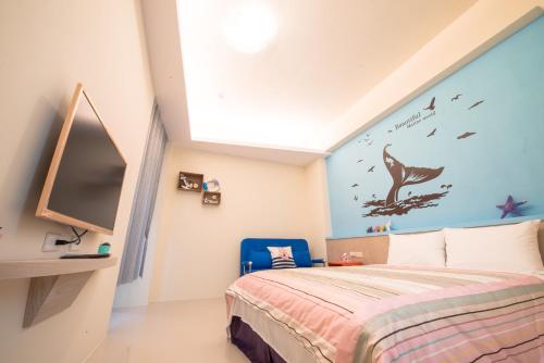 a bedroom with a bed and a wall with a fish mural at Travel Friends in Huxi