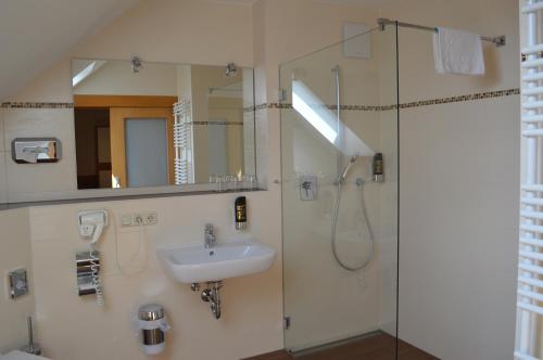 a bathroom with a sink and a shower at Hotel Daimerwirt in Moosinning