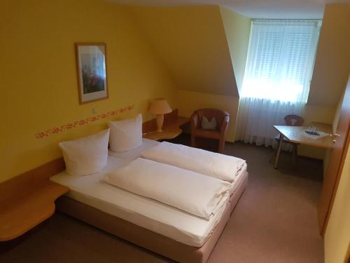 um quarto com uma cama, uma mesa e uma janela em Gasthof Krapp em Litzendorf