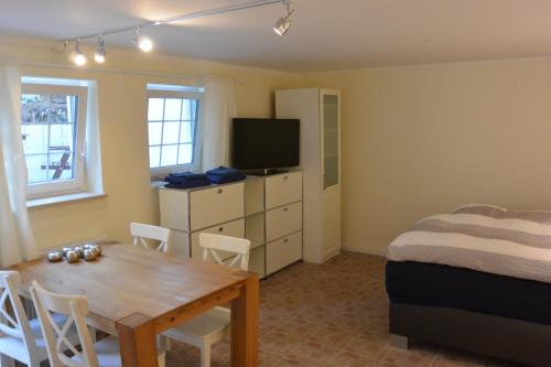 Zimmer mit einem Tisch und einem Bett sowie einem Schlafzimmer in der Unterkunft Ferienwohnung am Meer in Scharbeutz