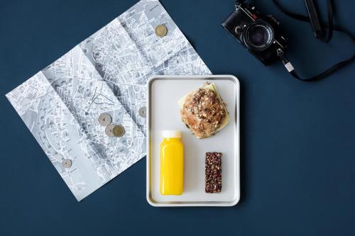 a plate of food and a bottle of orange juice at Steel House Copenhagen in Copenhagen