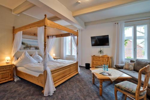 ein Schlafzimmer mit einem Himmelbett und ein Wohnzimmer in der Unterkunft Hotel Packhaus in Hooksiel