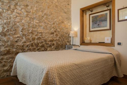 Un pat sau paturi într-o cameră la Locanda dell'Arcangelo