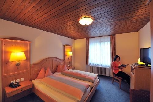 a woman sitting in a chair in a hotel room at Hotel Engelberg "mein Trail Hotel" in Engelberg