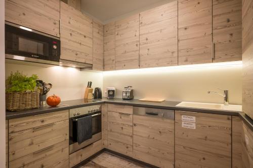 a kitchen with wooden cabinets and a sink at Aparthotel Backstage in Kufstein