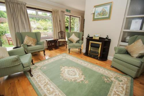 a living room with chairs and a fireplace at Dean Court Bungalow - Parking - by Brighton Holiday Lets in Rottingdean