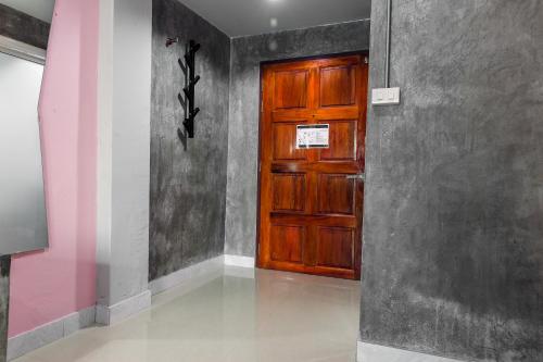 a wooden door in a room with a wall at The Guest Hotel Krabi in Krabi town