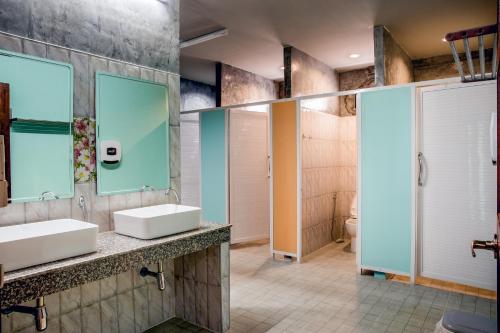 a bathroom with two sinks and two mirrors at The Guest Hotel Krabi in Krabi town