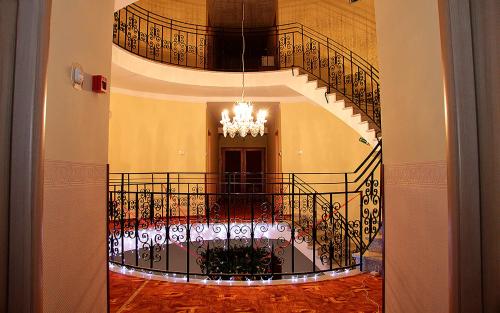 eine Wendeltreppe mit einem Kronleuchter in einem Gebäude in der Unterkunft Villa Lira in Hévíz