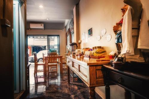 a kitchen with a wooden dresser and a dining room at The Guest Hotel Krabi in Krabi town