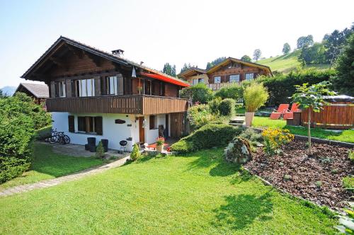 ein kleines Haus mit einem grünen Hof und einem Haus in der Unterkunft Chalet Tannegg in Reichenbach