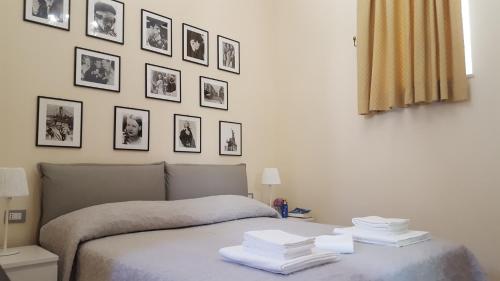 a bedroom with a bed with pictures on the wall at Dépendance La Casetta in Castellammare di Stabia