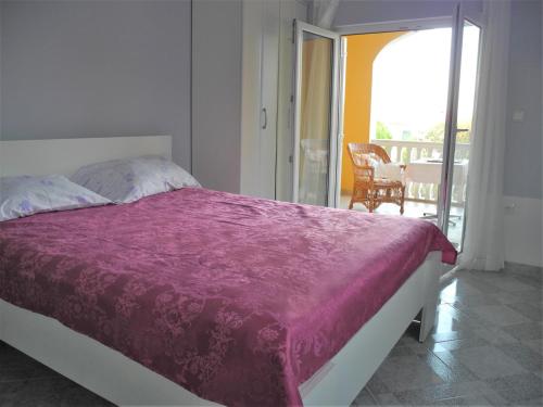 a bedroom with a bed with a purple blanket at Villa Ines in Jezera