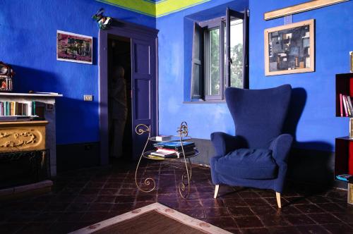 a living room with blue walls and a chair and a table at Lunafragola Atelier B&B in Candia Canavese