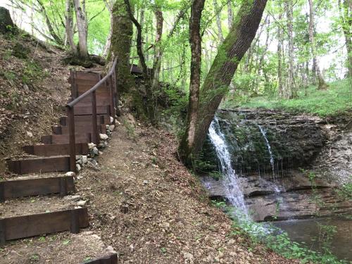 a staircase next to a waterfall in a forest at Casa Edith in Libano