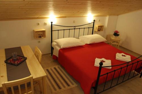 Novaki Motovunski的住宿－Guesthouse Casetta Verde，一间卧室配有红色的床、一张桌子和糕点