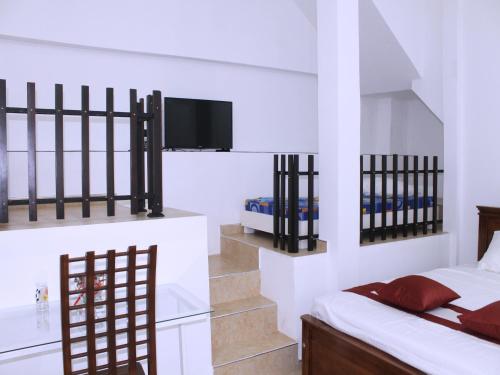a bedroom with a bed and a tv and stairs at Elliot Nature Resort in Galle
