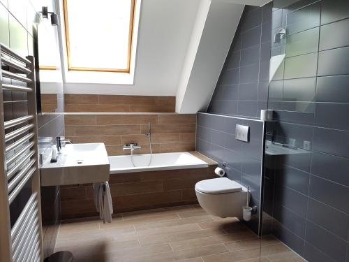 een badkamer met een bad, een toilet en een wastafel bij Rijksmonument Hotel de Sprenck in Middelburg
