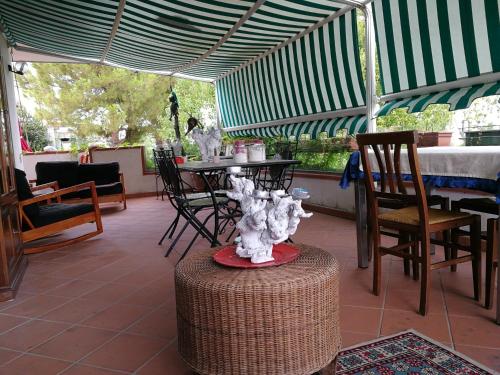 un patio con tavolo e sedie sotto una tenda. di The Incantation Guest House a Montesilvano