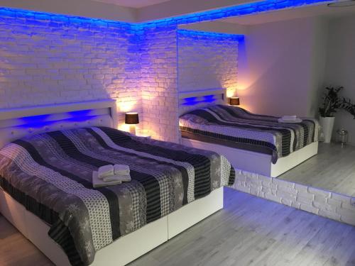 シュチェチンにあるCOCO Love Adults Only Apartament Szczecinの紫色の照明が備わる客室内のベッド2台