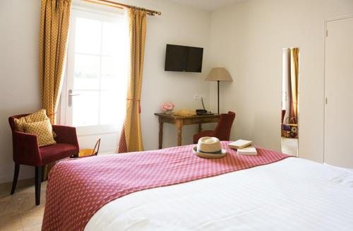 a bedroom with a bed with a hat and books at Hotellerie du Domaine de Cabasse in Séguret