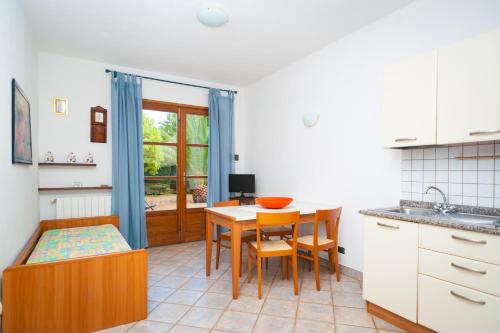 a kitchen with a table and chairs and a dining room at Appartamenti i Tigli in Capoliveri