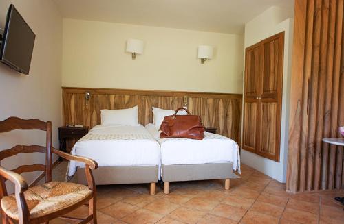 a bedroom with a bed with a purse on it at Hotellerie du Domaine de Cabasse in Séguret