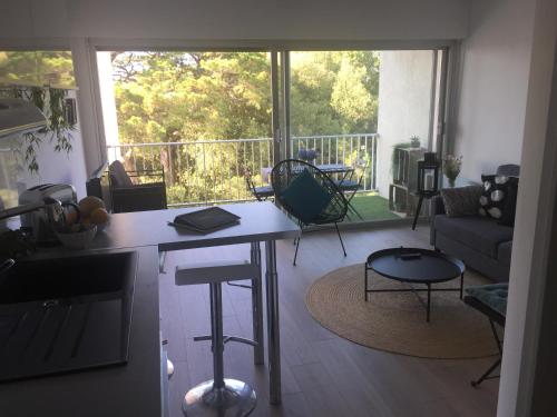 eine Küche und ein Wohnzimmer mit einem großen Fenster in der Unterkunft Au calme du bois du Pouliguen plage et port à pied in Le Pouliguen