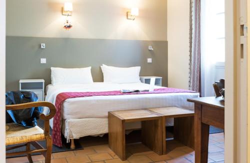 a hotel room with a bed and a table and a chair at Hotellerie du Domaine de Cabasse in Séguret