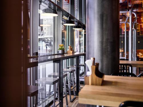 a bar with stools and tables in a restaurant at Jaz in the City Amsterdam in Amsterdam