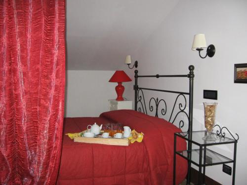 a bedroom with a red bed with a red curtain at Agriturismo La Gismonda in Bracciano