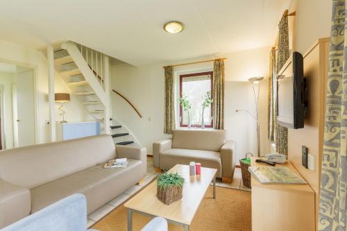 a living room with a couch and a table at Center Parcs Sandur Emmen in Emmen