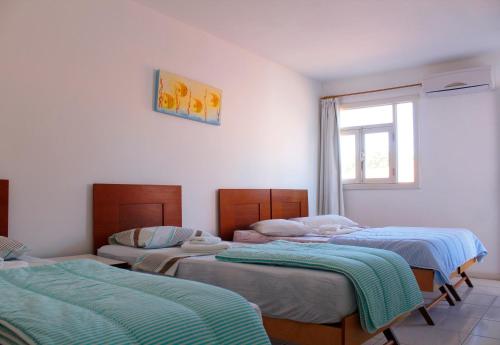 a group of three beds in a room at Deck de Búzios in Búzios