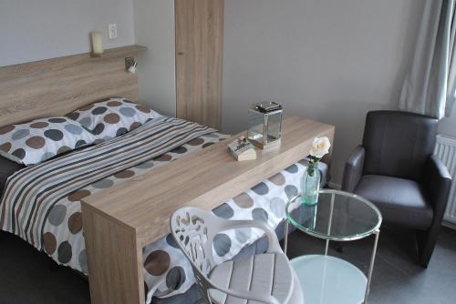 a bedroom with a bed and a table and a chair at Hotel Chalets Middelburg in Middelburg