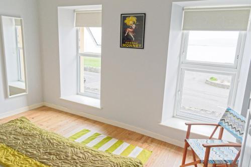 a living room with two windows and a couch at Harbour Bar Apartment in Greencastle