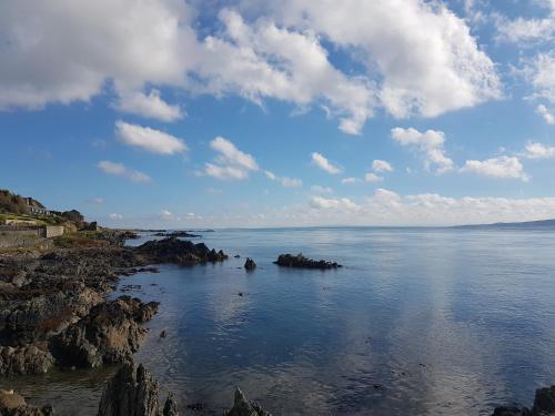 a view of the ocean with rocks in the water at Harbour Bar Apartment in Greencastle