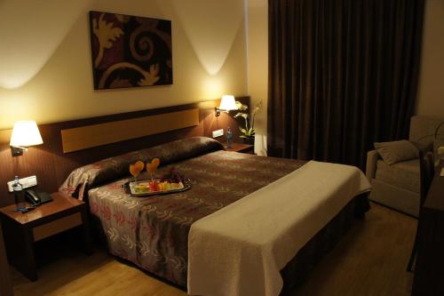 a hotel room with a bed with a tray of food on it at TCH Hotel in Lorquí