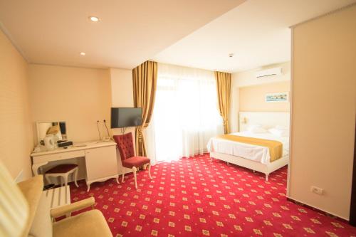 a hotel room with a bed and a desk at MSR Port Hotel in Mangalia
