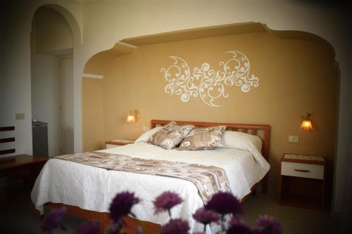 sypialnia z łóżkiem z żyrandolem na ścianie w obiekcie villa damecuta B&B w mieście Anacapri