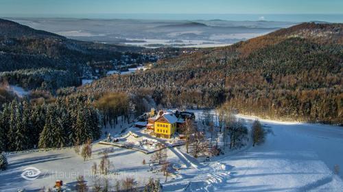 a yellow house in the middle of a snow covered mountain at Jánské kameny - Johannisstein in Krompach