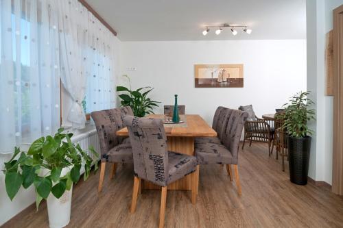 a dining room with a wooden table and chairs at Gästehaus Temitzhof in Latschach