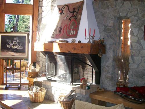 a fireplace in a living room with a stone wall at Aldea Bonita in Villa La Angostura