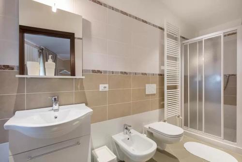 Baño blanco con lavabo y aseo en Villa Mereghetti, en Corbetta