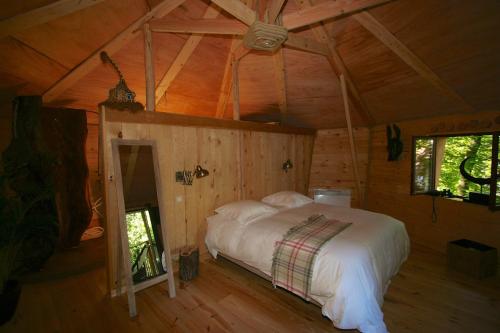 Een bed of bedden in een kamer bij B&B La Cabane du Bois Dormant