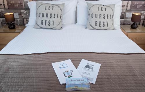 a bed with two pillows and certificates on it at Thornbank House Offering Breakfast and with the use of Free Local Health Club in Windermere