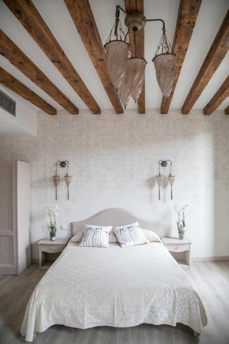 una camera da letto con un grande letto bianco con due tavoli di Guest House Ca' dell'Angelo a Venezia